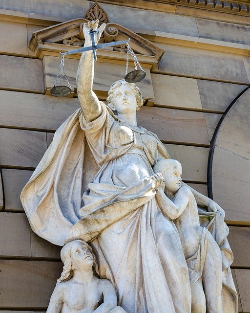 Vor dem Gericht ist Justizia zu sehen, da sie seit der Antike als Verkörperung der Gerechtigkeit gilt.
