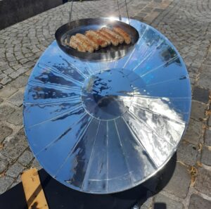 Der Parabolspiegel bündelt die Sonnenergie, die zum Grillen der Würstchen nötig ist